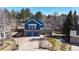 Beautiful two-story home featuring a brick and blue-sided facade, two-car garage, and mature landscaping at 7464 Shoreham Pl, Castle Pines, CO 80108