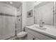 Clean bathroom featuring a glass-enclosed shower, a white vanity, and simple decor at 5078 S Quail St, Littleton, CO 80127
