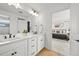 Bright bathroom features dual sinks, quartz countertop, with modern hardware with a peek into the bedroom at 5078 S Quail St, Littleton, CO 80127