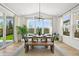 Sunlit dining area featuring a rustic wooden table and large windows with backyard view at 5078 S Quail St, Littleton, CO 80127