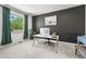Modern home office with dark accent wall, white desk, computer, chair, and a black and white longhorn picture at 5078 S Quail St, Littleton, CO 80127