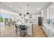 Open-concept kitchen with a large island, modern appliances, and a dining area at 5078 S Quail St, Littleton, CO 80127