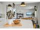 Bright kitchen island with quartz countertop and view into the living room with fireplace at 5078 S Quail St, Littleton, CO 80127