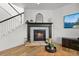 Cozy living room featuring a fireplace with stone surround and hardwood floors at 5078 S Quail St, Littleton, CO 80127