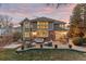 Spacious backyard with lush lawn, seating area, mature trees, and the home's exterior at 6132 S Boston Cir, Englewood, CO 80111