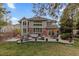 Well-manicured backyard with patio seating area, mature trees, and a spacious lawn at 6132 S Boston Cir, Englewood, CO 80111