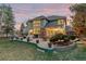 Backyard with spacious seating area, lush landscaping, and view of the brick home at 6132 S Boston Cir, Englewood, CO 80111