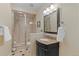 Bright bathroom featuring a walk-in shower with glass doors and vanity with granite countertop at 6132 S Boston Cir, Englewood, CO 80111