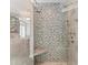 Modern bathroom shower with gray tile, glass door, and built-in bench for a spa-like experience at 6132 S Boston Cir, Englewood, CO 80111