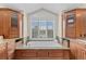 Bathroom soaking tub with custom wood cabinetry and a large window with white shutters at 6132 S Boston Cir, Englewood, CO 80111