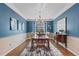Elegant dining room with blue walls, a modern chandelier, and a large dining table at 6132 S Boston Cir, Englewood, CO 80111