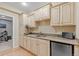 Bright kitchen with granite counters, stainless mini-fridge, custom cabinets, and adjacent seating area at 6132 S Boston Cir, Englewood, CO 80111