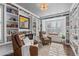Cozy living room featuring built-in bookshelves, a window seat, and two comfortable leather chairs at 6132 S Boston Cir, Englewood, CO 80111