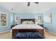 Spacious main bedroom featuring blue walls, vaulted ceilings, and a plush blue bench at the end of the bed at 6132 S Boston Cir, Englewood, CO 80111