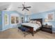 Bright main bedroom with vaulted ceilings, blue walls, shuttered windows, and a dark wood bed frame at 6132 S Boston Cir, Englewood, CO 80111
