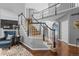Elegant staircase with white railing and dark wood accents in a well-lit foyer at 6132 S Boston Cir, Englewood, CO 80111
