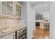 Convenient wet bar featuring a wine fridge and granite countertops, steps away from the kitchen at 6132 S Boston Cir, Englewood, CO 80111