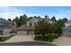 Charming two-story home with a brick facade, mature trees, a two car garage, and a well-manicured lawn at 6132 S Boston Cir, Greenwood Village, CO 80111