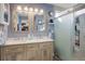 Bright bathroom features a double sink vanity, wood-framed mirrors, and a modern glass-enclosed shower at 11701 Elkhart St, Commerce City, CO 80603
