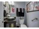 Stylish half bathroom with modern fixtures, dark wood vanity, and decorative accents at 11701 Elkhart St, Commerce City, CO 80603