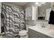 Cozy bathroom featuring a shower curtain, vanity, and storage cabinet for essentials at 11701 Elkhart St, Commerce City, CO 80603