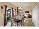 Open-concept dining area featuring a rustic table, a modern chandelier, and access to the outdoor patio at 11701 Elkhart St, Commerce City, CO 80603