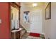 Welcoming entryway with a decorative mirror, a patterned rug, and a bright front door at 11701 Elkhart St, Commerce City, CO 80603