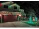 Festive home exterior decorated with colorful lights and charming holiday decorations at night at 11701 Elkhart St, Commerce City, CO 80603