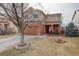 Inviting two-story home with a brick facade, a manicured lawn, and an American flag at 11701 Elkhart St, Commerce City, CO 80603