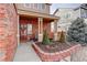 Inviting front porch featuring brick accents, neutral paint, and decorative landscaping at 11701 Elkhart St, Commerce City, CO 80603