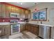 Updated kitchen features stainless steel appliances, light countertops, and wood cabinets at 11701 Elkhart St, Commerce City, CO 80603