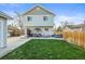 View of the home's backyard with grass, and patio set with an umbrella at 4942 Grove St, Denver, CO 80221