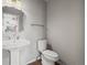 This bathroom features a white sink with silver faucet, toilet, and dark flooring at 4942 Grove St, Denver, CO 80221