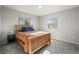 Bedroom features carpet, two windows that provide natural light, and a bed with blue pillows at 4942 Grove St, Denver, CO 80221