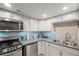 Well-lit kitchen featuring stainless steel appliances and a stylish tile backsplash, perfect for modern living at 4942 Grove St, Denver, CO 80221