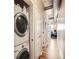 Hallway with in-unit washer and dryer and wood floors that transition to carpet further down the hall at 1441 Central # 305, Denver, CO 80211