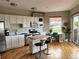Bright kitchen featuring white cabinets, stainless steel appliances, island with seating, and hardwood floors at 1441 Central # 305, Denver, CO 80211