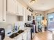 Bright kitchen with stainless steel appliances, double sink, and white cabinets; flows to dining space at 1441 Central # 305, Denver, CO 80211