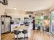 Open kitchen with white cabinets, stainless steel appliances, an island, and hardwood floors at 1441 Central # 305, Denver, CO 80211