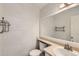 Bathroom features a large mirror, sink, toilet, and wood-look paneling at 8717 Carr Loop, Arvada, CO 80005