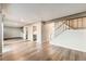 Open concept living room with staircase, wood floors, and access to the kitchen at 8717 Carr Loop, Arvada, CO 80005