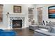 Modern fireplace with a unique mosaic tile surround and neutral color scheme at 10993 Ledges Rd, Parker, CO 80134