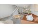 Inviting living room with wood floors, stylish decor, staircase, and seamless flow into the modern kitchen at 1818 S Quebec Way # 3-4, Denver, CO 80231