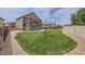 Expansive backyard featuring a lush lawn, stone accents, and an outdoor patio with seating and a barbecue grill at 12578 Hudson Ct, Thornton, CO 80241