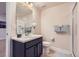 Clean bathroom featuring a single sink vanity, large mirror, tiled floors, and a glass-enclosed shower at 12578 Hudson Ct, Thornton, CO 80241