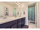 Dual sink bathroom with dark cabinetry, decorative starfish art, and a shower/tub combination at 12578 Hudson Ct, Thornton, CO 80241