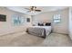 This is a neutral bedroom with a queen bed, white headboard, ceiling fan, and natural light from three windows at 12578 Hudson Ct, Thornton, CO 80241