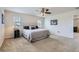 This is a neutral bedroom with a queen bed, white headboard, ceiling fan, carpet, and natural light at 12578 Hudson Ct, Thornton, CO 80241