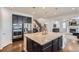 Open concept kitchen with island, stainless steel appliances, and easy access to the living room and stairway at 12578 Hudson Ct, Thornton, CO 80241