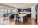 Modern kitchen featuring a large island, granite countertops, dark wood cabinets, and stainless steel appliances at 12578 Hudson Ct, Thornton, CO 80241